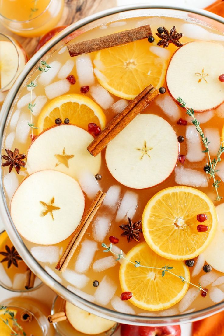 an apple cider with orange slices and cinnamon sticks