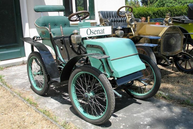 an old fashioned car is parked in front of a building