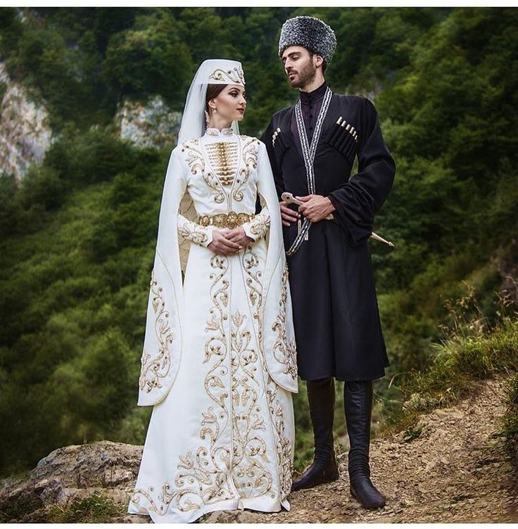 a man and woman dressed in medieval clothing standing next to each other on a hill