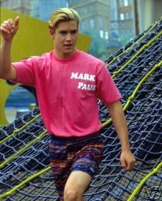 a young man in pink shirt and blue shorts running on a trampoline course