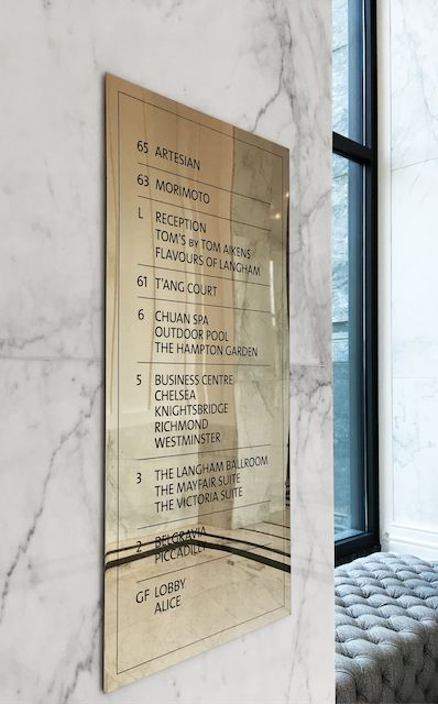 a marble bench in front of a wall with a plaque on it's side