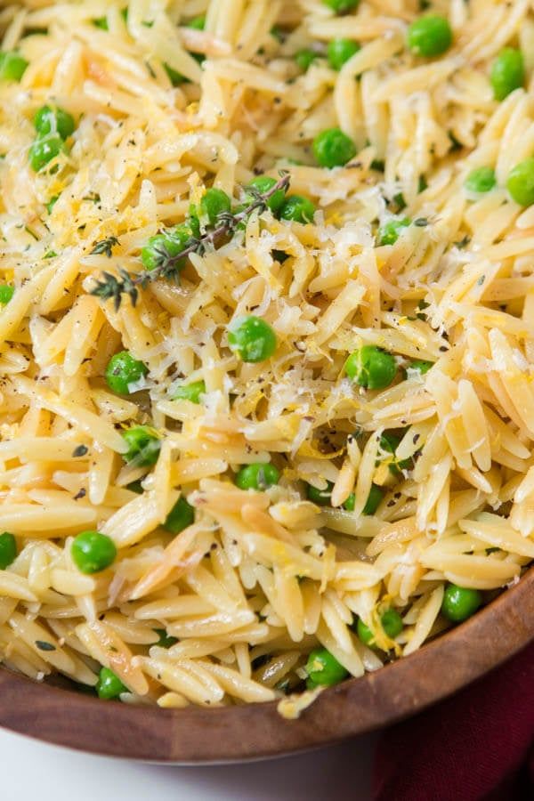 pasta with peas and parmesan cheese in a wooden bowl