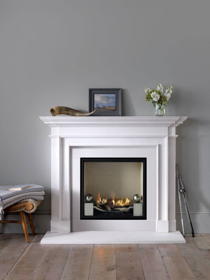 a white fireplace in a living room with wood floors