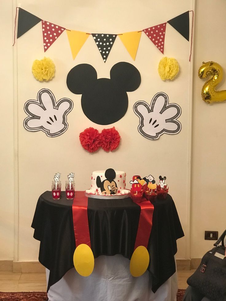 a mickey mouse birthday party with cake and decorations