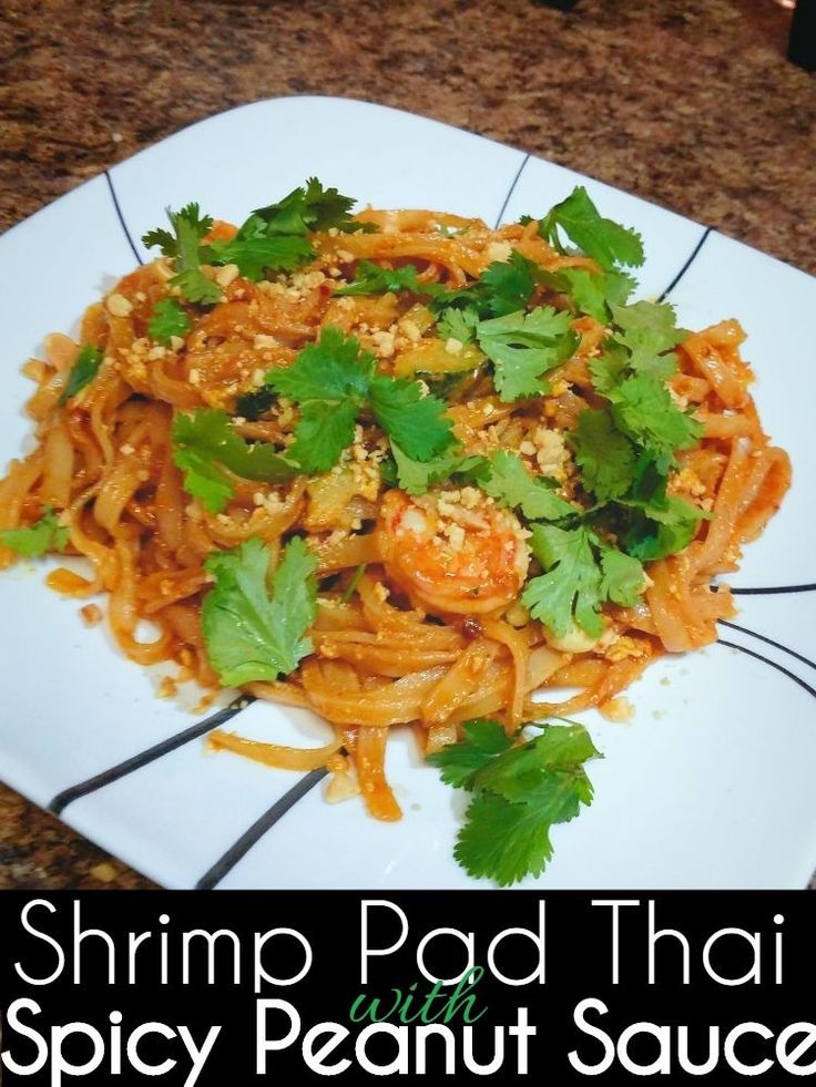 shrimp pad thai spicy peanut sauce on a white plate with parsley garnish