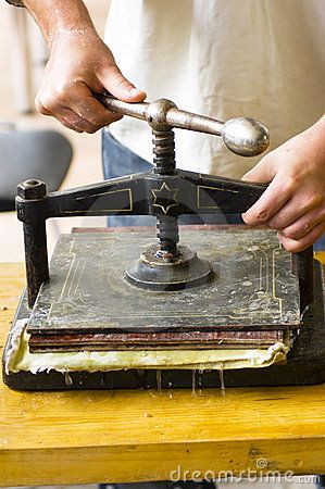 a man is working with an old fashioned machine on a wooden table in front of him