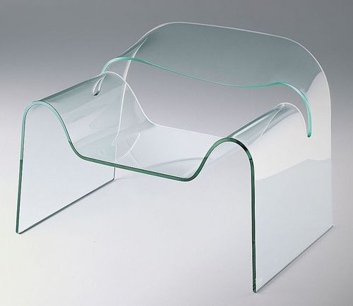 a clear glass chair sitting on top of a white table