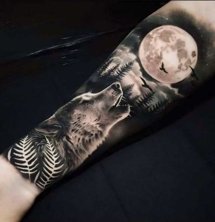 a man's arm with a wolf tattoo on it and the moon in the background