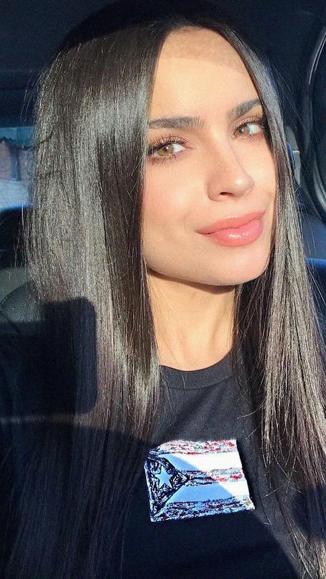 a woman with long grey hair sitting in a car