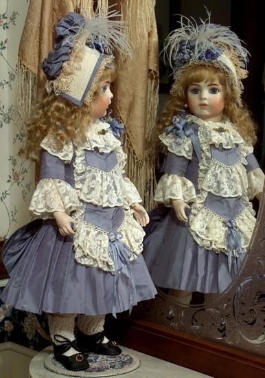 two dolls standing next to each other in front of a mirror with lace on them