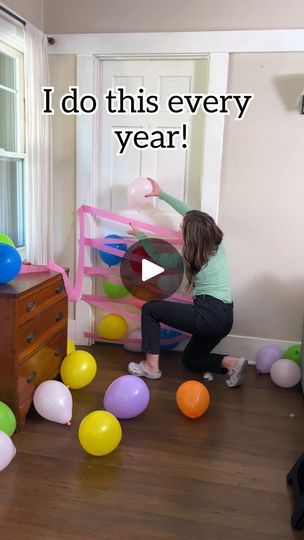 a woman is playing with balloons in the living room