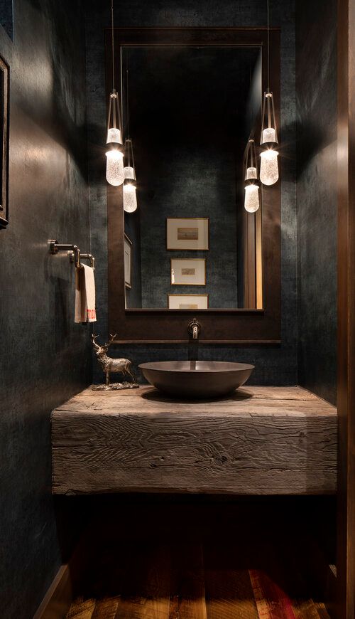 a bathroom sink sitting under a mirror next to a wooden counter topped with a bowl