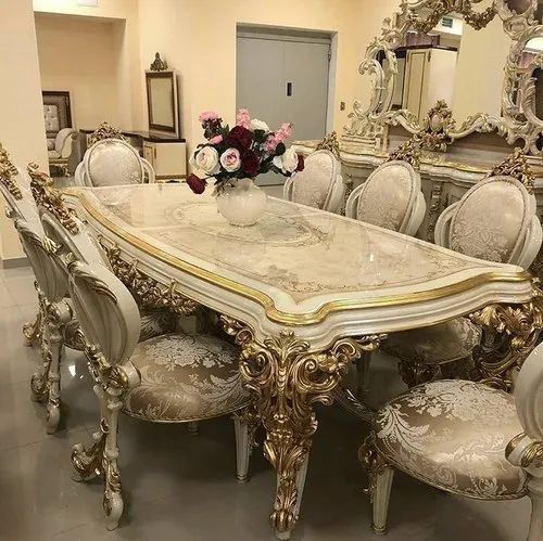 a dining room table with chairs and a vase filled with flowers