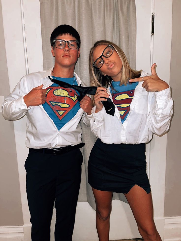 a man and woman dressed up as supermans posing for the camera with their hands on their hips