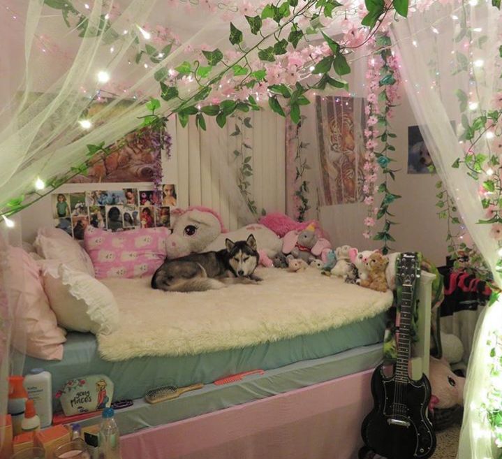 a dog laying on top of a bed covered in pink flowers