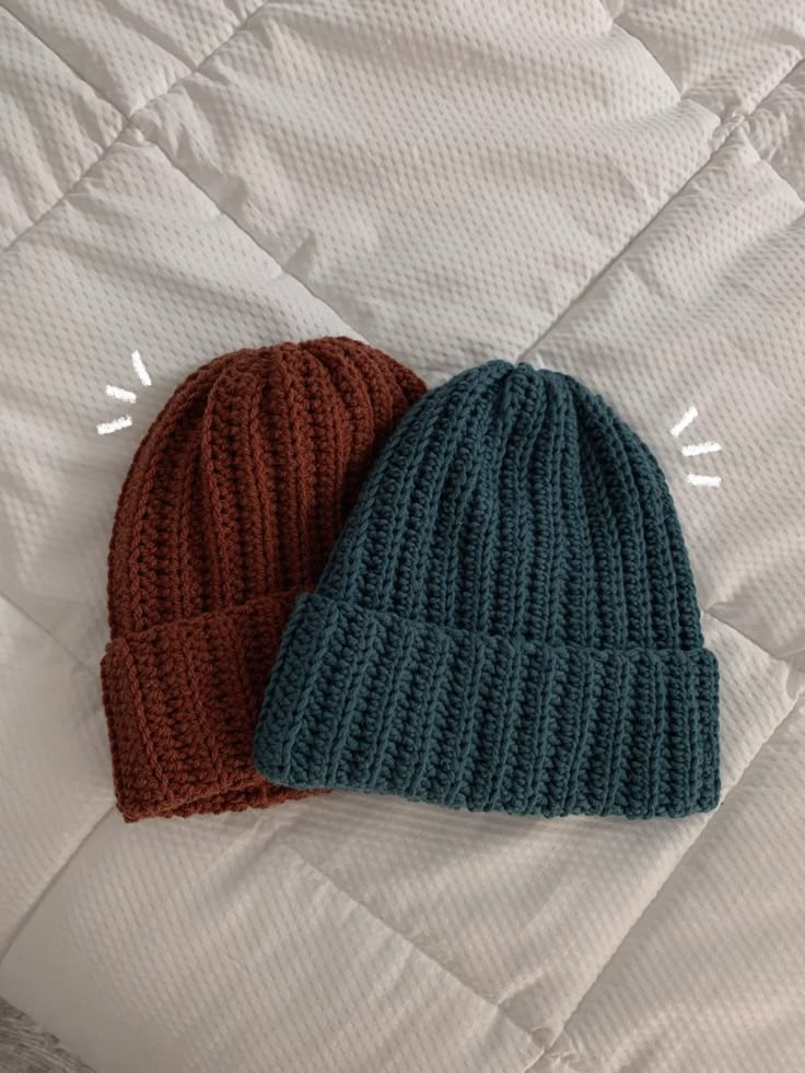 two knitted hats laying on top of each other