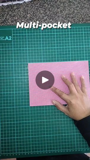 a person is making a pink piece of paper with their hand and thumb on it