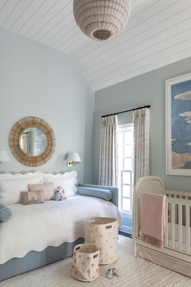 a baby's room with blue walls and white furniture