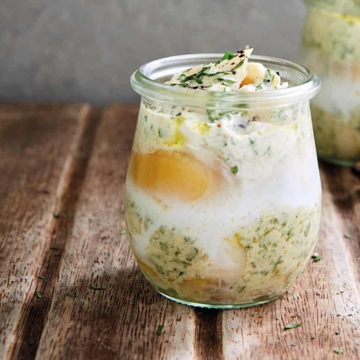 two jars filled with food sitting on top of a wooden table