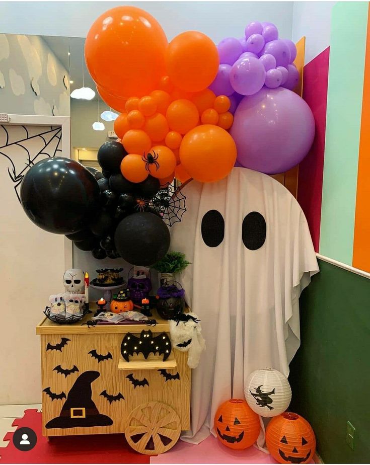 halloween decorations and balloons are on display in a room that is decorated with orange, purple, and black