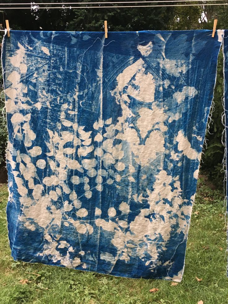 a blue and white tie - dyed cloth hanging on clothesline