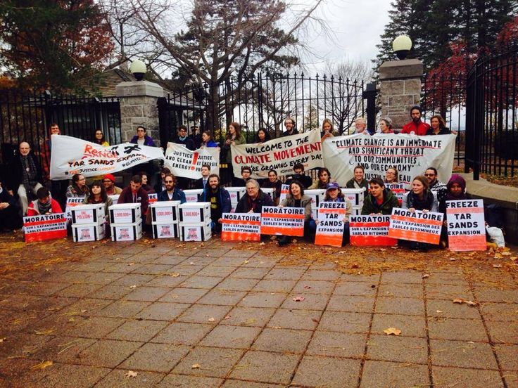 a group of people holding up signs in front of a gate