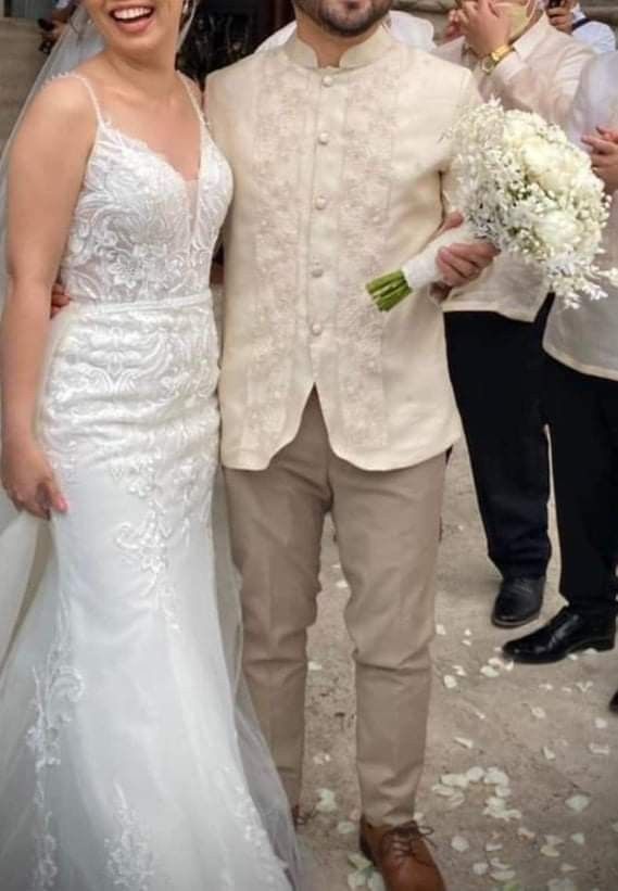 a man and woman standing next to each other in front of some people holding flowers