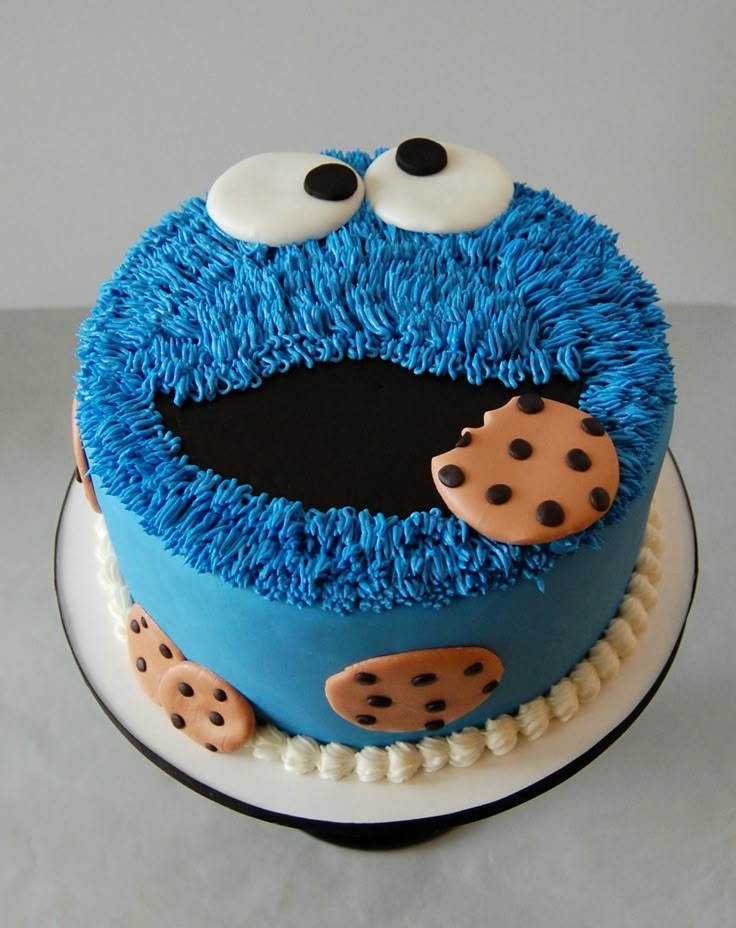 a birthday cake with blue frosting and chocolate chip cookie cookies on the bottom layer