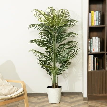 a potted plant sitting on top of a wooden chair next to a book shelf