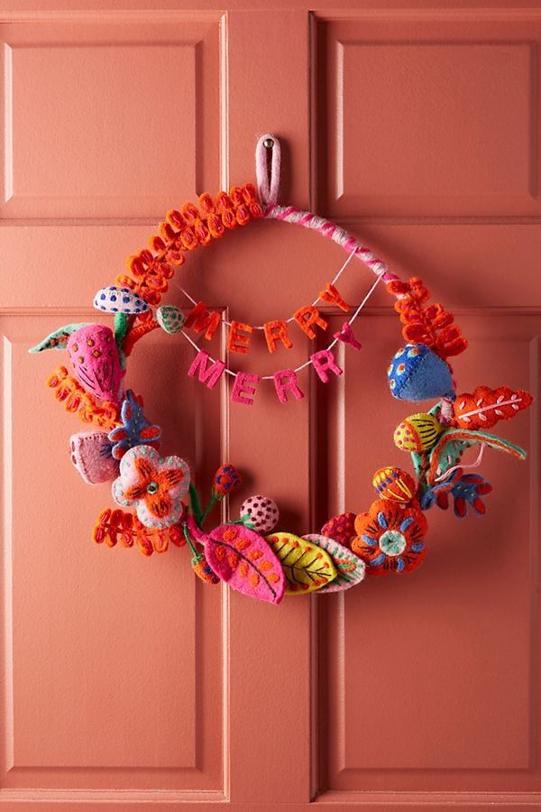 a pink door with a wreath hanging on it