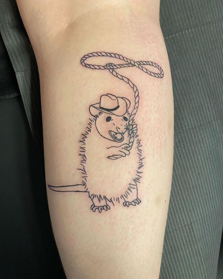 a rat with a cowboy hat and rope tattoo on the arm