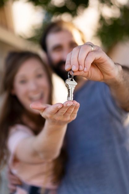 a man holding a key to a woman's chest and smiling at the camera