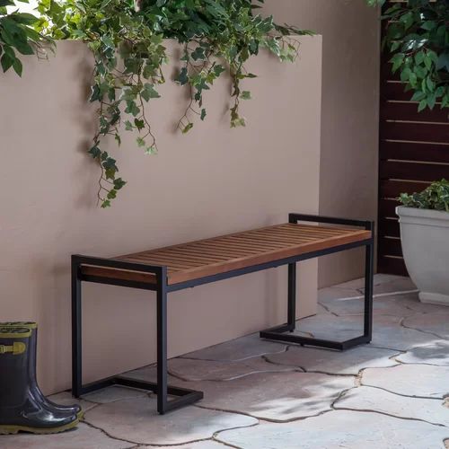 a wooden bench sitting next to a potted plant