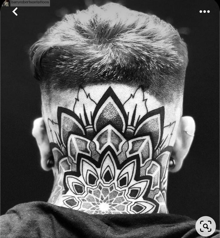 the back of a man's head with tattoos on his face and neck,