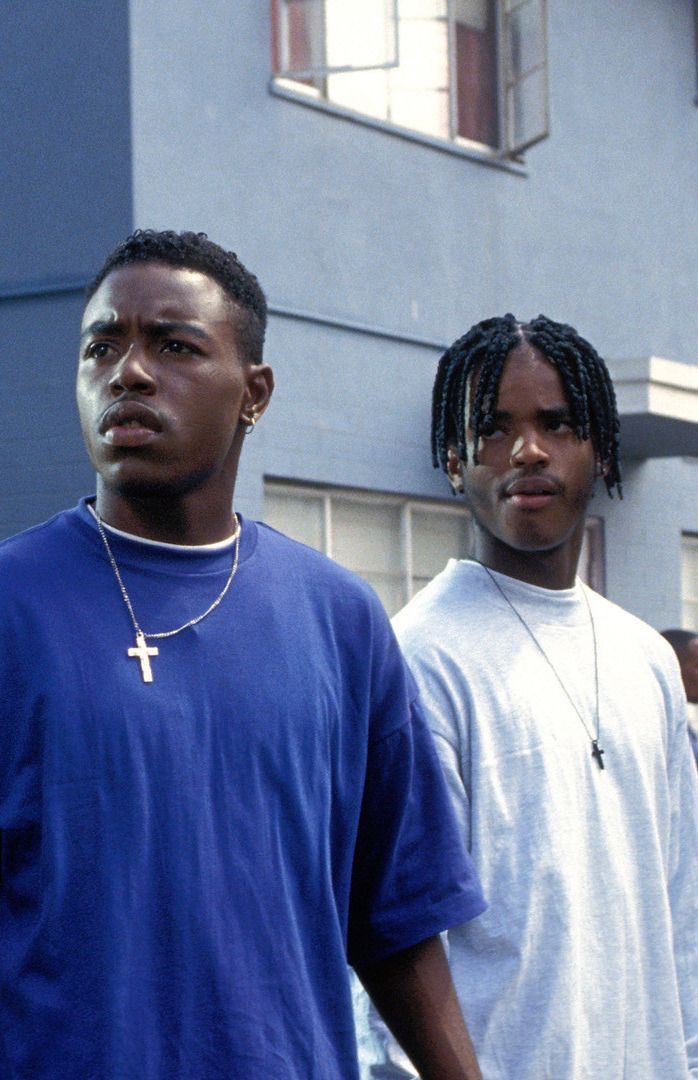 three young men standing next to each other in front of a building with a cross on it