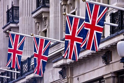 three british flags are hanging from the side of a building in london, united kingdom