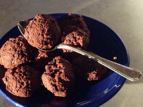 a blue bowl filled with chocolate truffles and a spoon