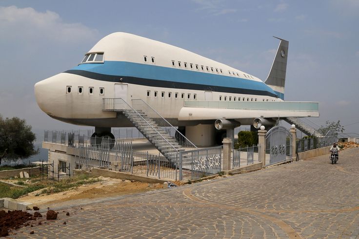 a large white and blue airplane sitting on top of a building