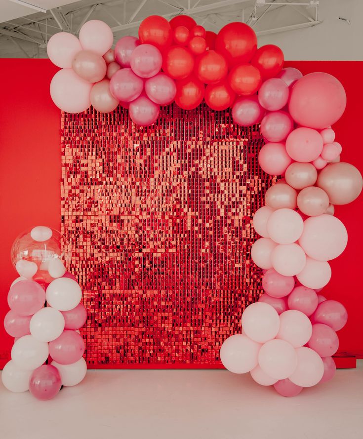 red and white balloons are in front of a wall with sequins on it