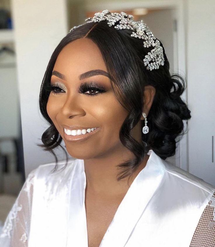 a woman wearing a bridal headpiece with pearls on it's hair and smiling at the camera