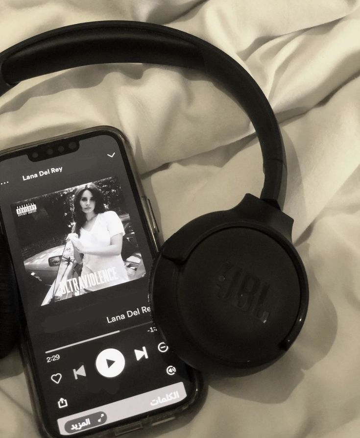 an ipod and headphones laying on top of a bed