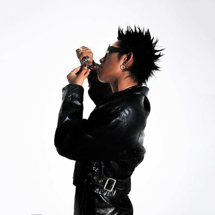 a woman in black leather clothes drinking from a bottle