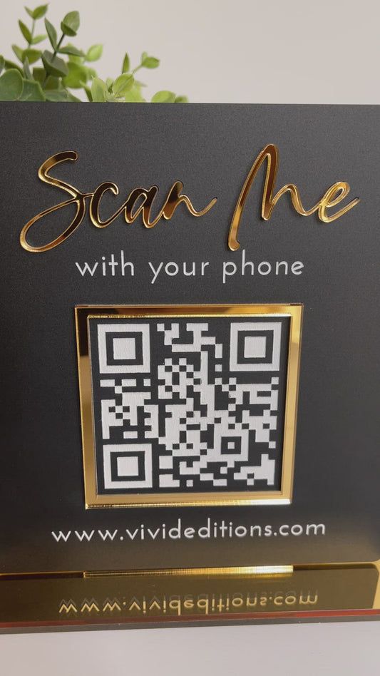 a black and gold sign with the words scan me with your phone written on it