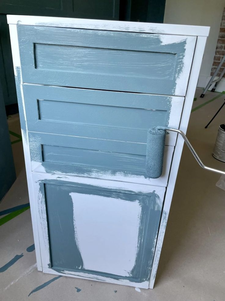 an unfinished cabinet painted in blue and white