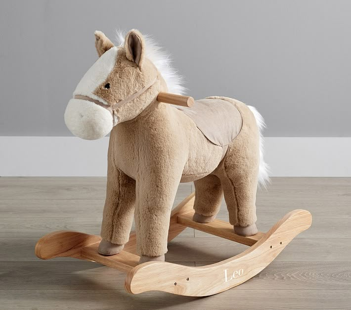 a stuffed horse on a wooden rocking toy