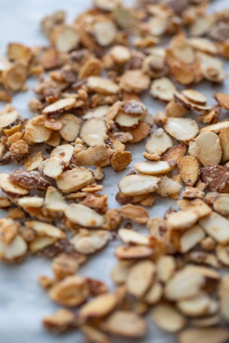 nuts are scattered on top of a sheet of parchment paper, ready to be eaten