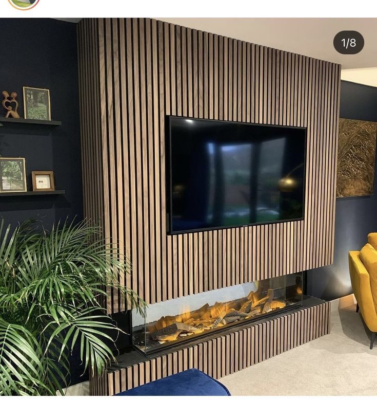 a living room with a large television mounted on the wall next to a fire place