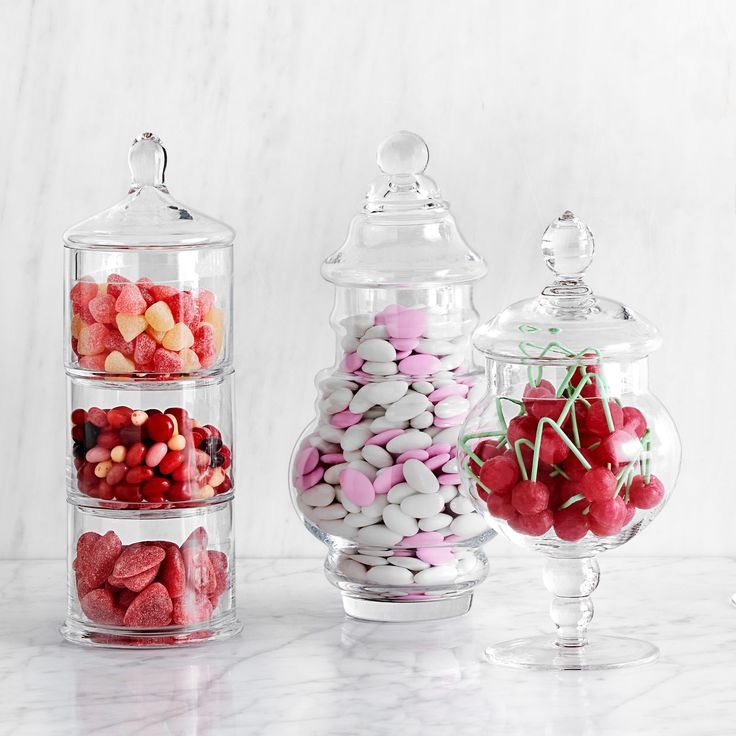 three glass containers filled with candy and candies