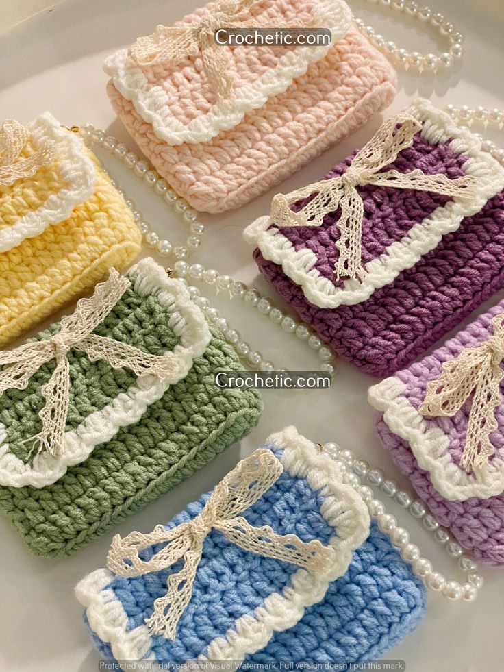 four crocheted purses with bows on them