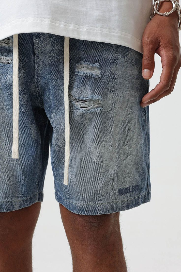 Bring an edgy touch to your casual wear with the Contrast Texture Ripped Denim Shorts. This pair is thoughtfully ripped throughout, adding a grungy twist to the classic washed blue color. With an elastic waistband design, which is highly unusual for denim shorts, you get the benefit of both style and comfort. The extended drawstrings allow for a customizable fit, adding to the unique appeal of these must-have shorts. Ripped throughout for a grungy aesthetic Classic washed blue color Elastic wais Distressed Jean Shorts For Summer Streetwear, Denim Blue Shorts With Frayed Hem For Streetwear, Trendy Washed Denim Blue Jean Shorts, Spring Ripped Jean Shorts For Streetwear, Ripped Cotton Short Jeans, Short Ripped Cotton Jeans, Ripped Cotton Jeans, Spring Distressed Shorts For Streetwear, Ripped Relaxed Fit Casual Shorts